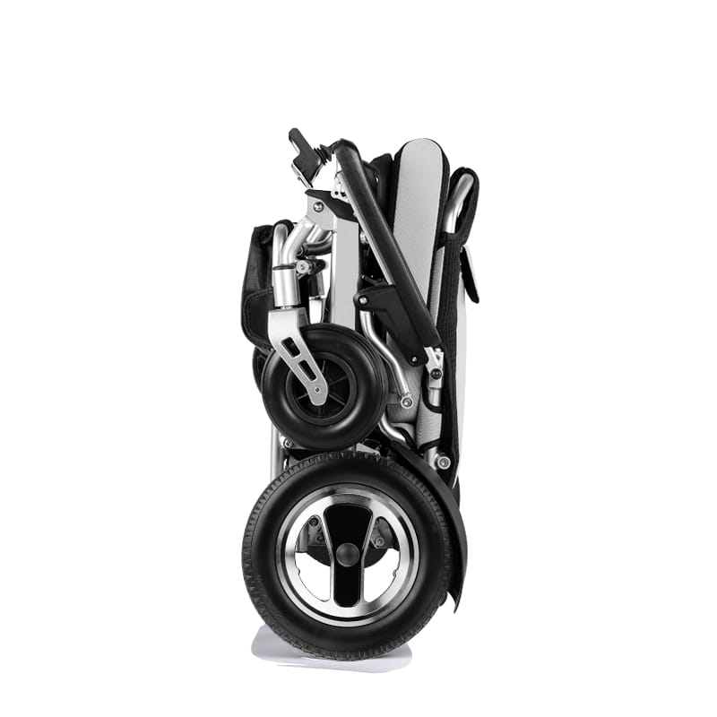 Person using a lightweight travel wheelchair in a city